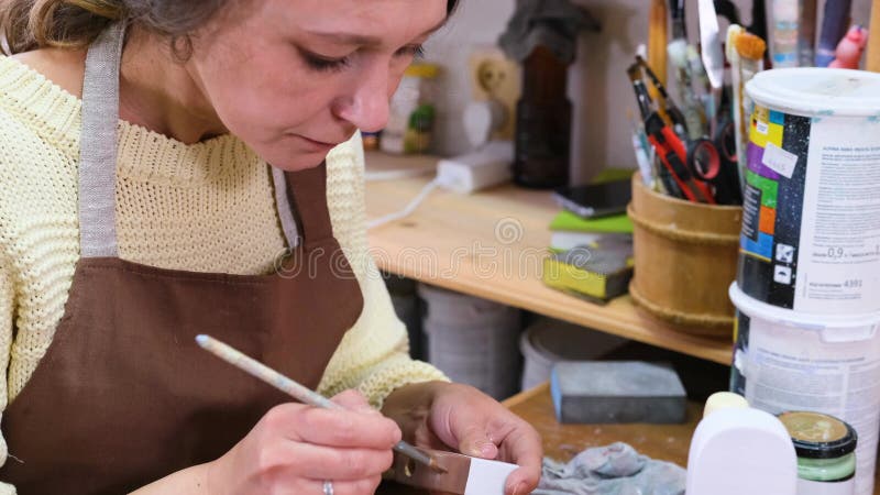 De meester schildert houten speelgoed met acrylverven. productie van milieuvriendelijk speelgoed voor kinderen