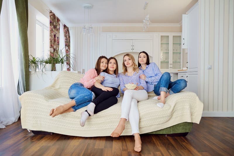 De meisjes letten TV-op zitting op de laag stock foto De meisjes letten TV-op zitting op de laag stock foto