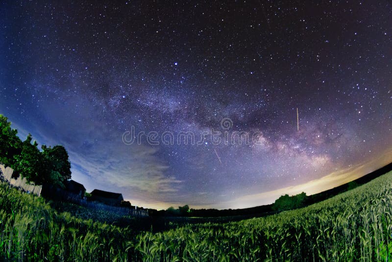 Milky way stars galaxy shot with fisheye near a rural house in a wheat field. Milky way stars galaxy shot with fisheye near a rural house in a wheat field