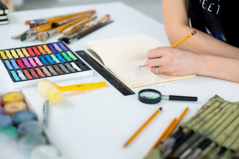 De mening van de close-uphoek van een vrouwelijk ontwerp van de schilderstekening bij sketchbook die potlood gebruiken Kunstenaar royalty-vrije stock afbeelding De mening van de close-uphoek van een vrouwelijk ontwerp van de schilderstekening bij sketchbook die potlood gebruiken Kunstenaar royalty-vrije stock afbeelding