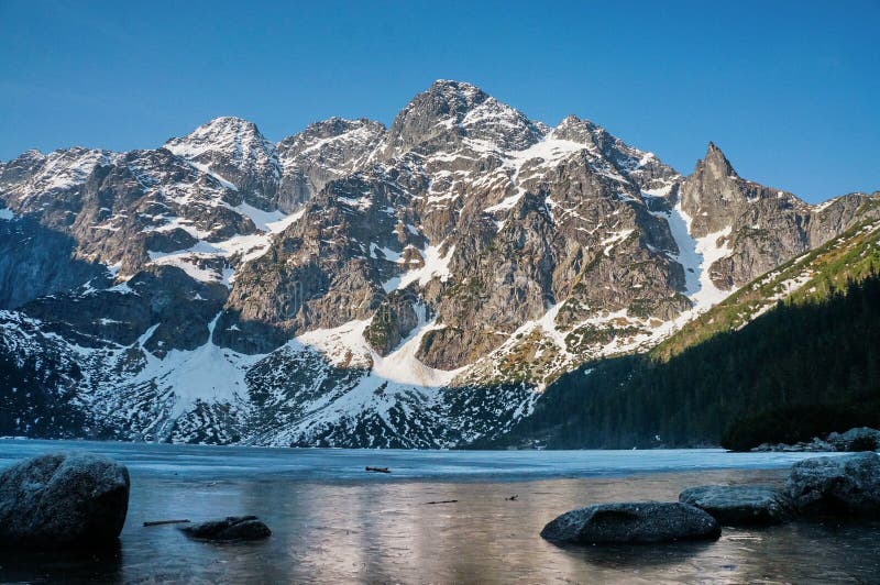 de mening van sneeuw behandelde bergpieken over meerwater, Morskie Oko, Overzees Oog, Nationale Tatra