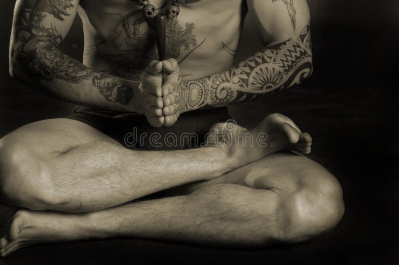 De mens die van de tatoegering yoga doet royalty-vrije stock afbeelding De mens die van de tatoegering yoga doet royalty-vrije stock afbeelding