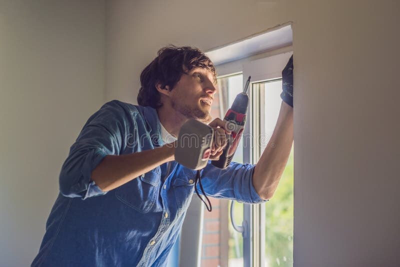 De mens in een blauw overhemd doet vensterinstallatie royalty-vrije stock afbeeldingen De mens in een blauw overhemd doet vensterinstallatie royalty-vrije stock afbeeldingen