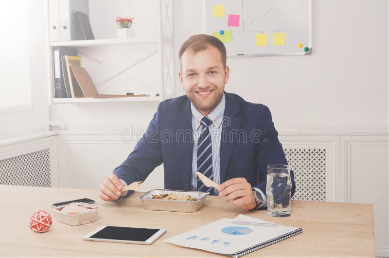De mens heeft gezonde bedrijfslunch in modern bureaubinnenland royalty-vrije stock afbeelding De mens heeft gezonde bedrijfslunch in modern bureaubinnenland royalty-vrije stock afbeelding