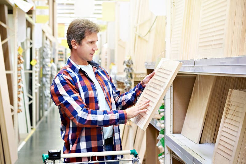 De mens kiest houten voorgevels voor meubilair in opslag royalty-vrije stock foto De mens kiest houten voorgevels voor meubilair in opslag royalty-vrije stock foto