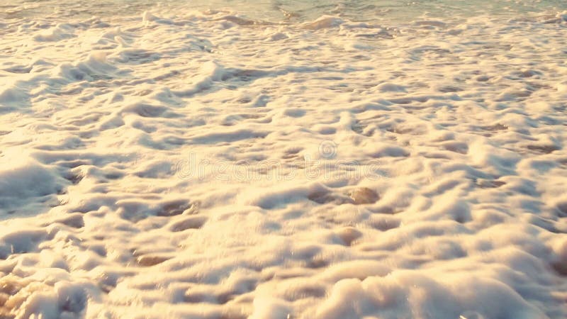 De mens loopt op het strand Overzeese golven die zijn benen wassen