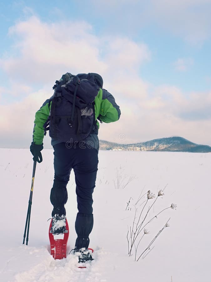 De mens met sneeuwschoenen en de rugzak nemen foto's door smartphone Wandelaar in sneeuwbank royalty-vrije stock foto's De mens met sneeuwschoenen en de rugzak nemen foto's door smartphone Wandelaar in sneeuwbank royalty-vrije stock foto's
