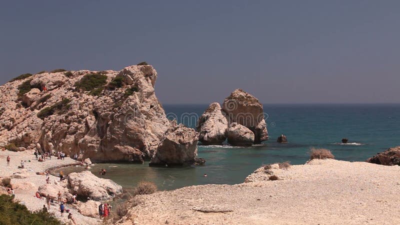 De mensen baden uit en zonnebaden op een klein zandig strand, de geboorteplaats van Aphrodite op het Eiland Cyprus, Rotsenstok stock video De mensen baden uit en zonnebaden op een klein zandig strand, de geboorteplaats van Aphrodite op het Eiland Cyprus, Rotsenstok stock video