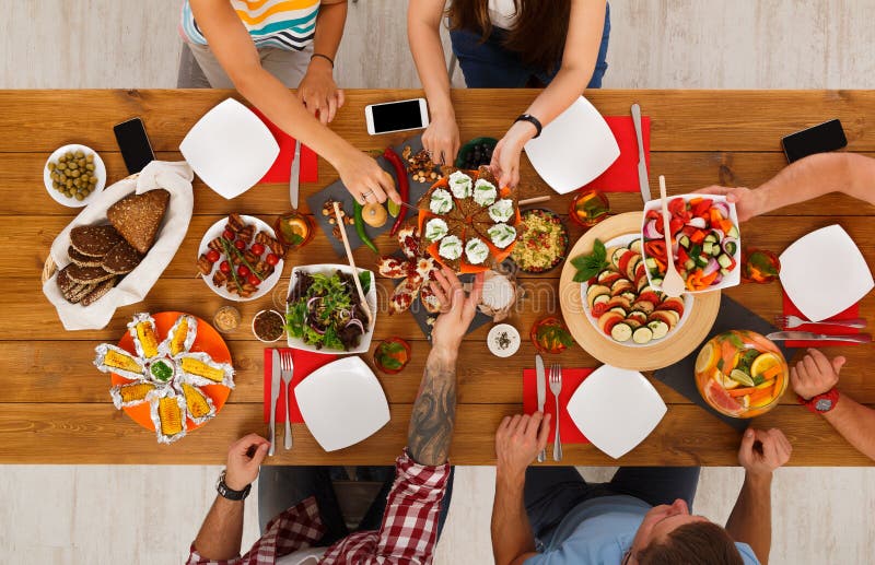 De mensen eten gezonde maaltijd bij de gediende partij van het lijstdiner royalty-vrije stock fotografie De mensen eten gezonde maaltijd bij de gediende partij van het lijstdiner royalty-vrije stock fotografie