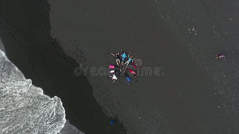 De mensen liggen op het zwarte strand Reynisfyara Andreev