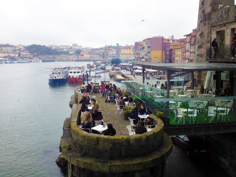 De mensen ontspannen in een koffie op de waterkant in het historische Ribeira district Porto, Portugal royalty-vrije stock foto's De mensen ontspannen in een koffie op de waterkant in het historische Ribeira district Porto, Portugal royalty-vrije stock foto's