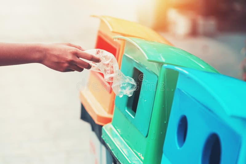 de mensen overhandigen de flessenplastiek van het holdingshuisvuil zettend in kringloopbak voor het schoonmaken stock afbeelding de mensen overhandigen de flessenplastiek van het holdingshuisvuil zettend in kringloopbak voor het schoonmaken stock afbeelding