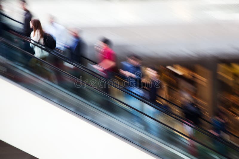 De mensen van het motieonduidelijke beeld op een roltrap stock fotografie De mensen van het motieonduidelijke beeld op een roltrap stock fotografie