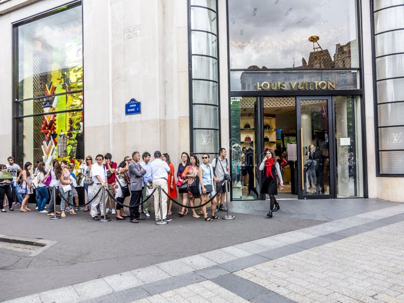 De mensen vormen omhoog voor Louis Vuitton-winkel een rij stock foto De mensen vormen omhoog voor Louis Vuitton-winkel een rij stock foto
