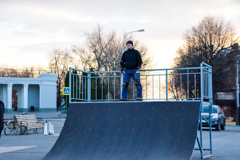 De mensenrol die van de vrije tijdsactiviteit in centraal van de stad op de zonsondergang schaatsen De winter royalty-vrije stock foto's De mensenrol die van de vrije tijdsactiviteit in centraal van de stad op de zonsondergang schaatsen De winter royalty-vrije stock foto's