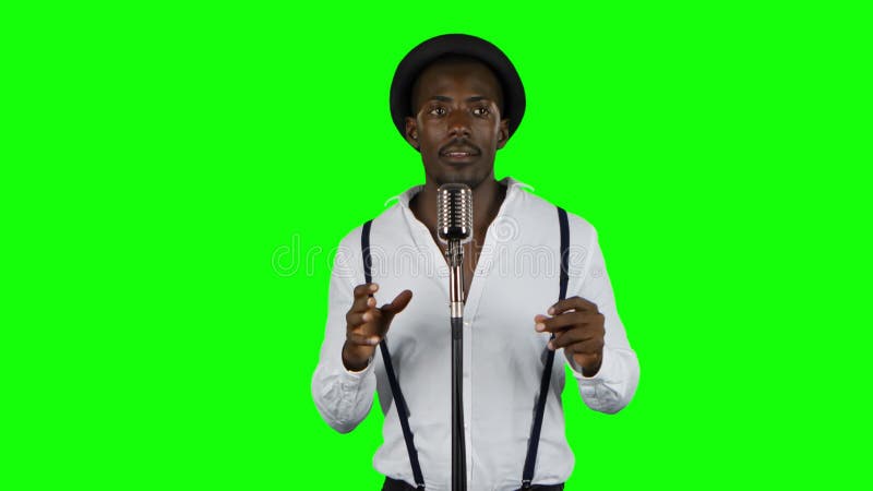 De mensenzanger zingt in een microfoon en een dans Het groene scherm
