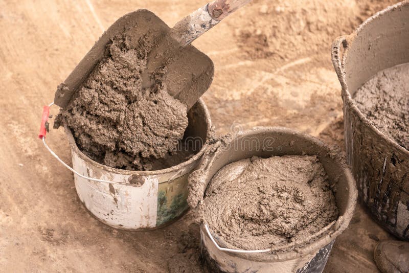 De metselaar kneedt cementmortier voor het gieten van concrete screed royalty-vrije stock foto De metselaar kneedt cementmortier voor het gieten van concrete screed royalty-vrije stock foto