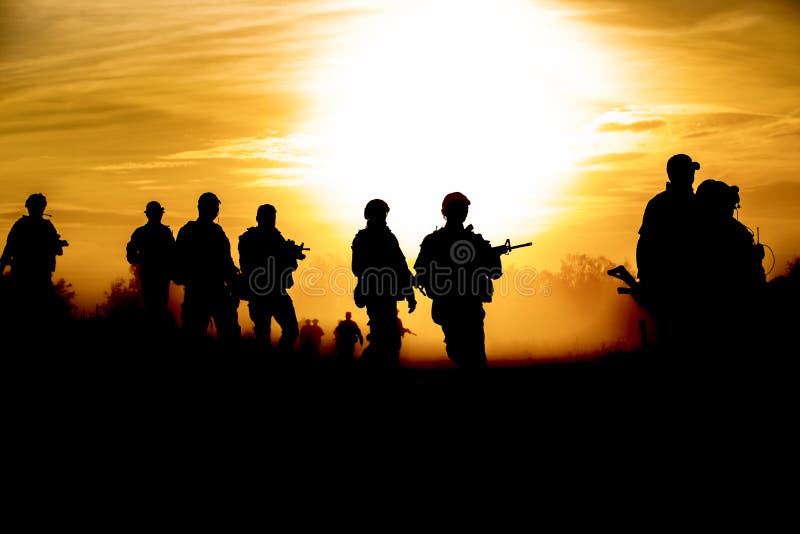 De militairen die van de silhouetactie greepwapens lopen de achtergrond is rook en zonsondergang en witbalansschipeffect dark