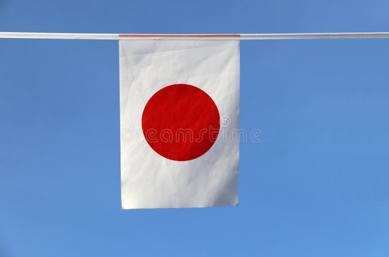 De minivlag van het stoffenspoor van Japan, het is een rechthoekige witte banner die een karmozijnrood-rode schijf dragen op zijn royalty-vrije stock afbeeldingen De minivlag van het stoffenspoor van Japan, het is een rechthoekige witte banner die een karmozijnrood-rode schijf dragen op zijn royalty-vrije stock afbeeldingen