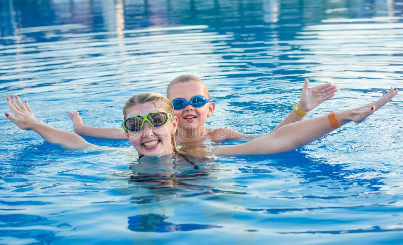 De moeder en de zoon in glazen voor het zwemmen zwemmen in de pool De vakantie van de familie royalty-vrije stock foto De moeder en de zoon in glazen voor het zwemmen zwemmen in de pool De vakantie van de familie royalty-vrije stock foto