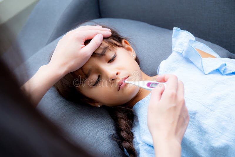 De moederhand die temperatuur met meisje vergen is zieken die op bank, Jong geitjepatiënt met de thermometer van de mammacontrole royalty-vrije stock afbeeldingen De moederhand die temperatuur met meisje vergen is zieken die op bank, Jong geitjepatiënt met de thermometer van de mammacontrole royalty-vrije stock afbeeldingen