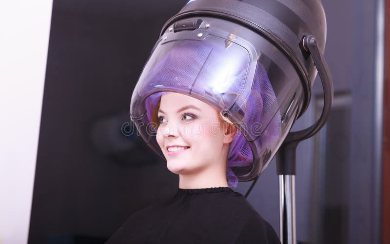 De mooie blonde van de krulspeldenrollen van het meisjeshaar salon van de de kapperschoonheid stock foto De mooie blonde van de krulspeldenrollen van het meisjeshaar salon van de de kapperschoonheid stock foto