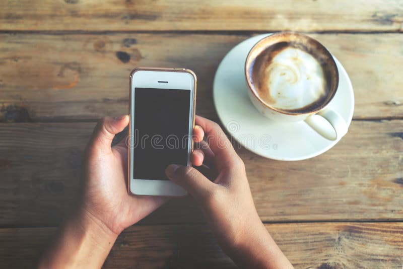 De mooie jonge handen die van de hipstervrouw ` s mobiele slimme telefoon met hete koffiekop houden bij koffiewinkel, stock foto's De mooie jonge handen die van de hipstervrouw ` s mobiele slimme telefoon met hete koffiekop houden bij koffiewinkel, stock foto's