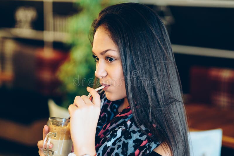 De mooie meisje het drinken schok van ijsmocha in een koffie royalty-vrije stock afbeelding De mooie meisje het drinken schok van ijsmocha in een koffie royalty-vrije stock afbeelding