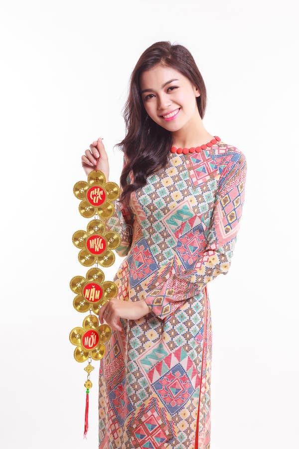 De mooie Vietnamese vrouw die indrukao dai dragen die gelukkig verfraait voorwerp houden
