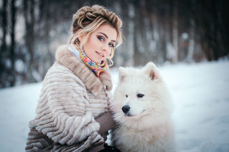 Beautiful woman with dog samoyed in winter forest. Beautiful woman with dog samoyed in winter forest.
