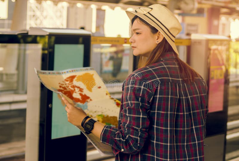 De mooie vrouwen die controleren hun reisroute met a reizen stock afbeelding De mooie vrouwen die controleren hun reisroute met a reizen stock afbeelding