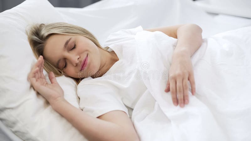 De mooie vrouwenslaap in bed, die goede dromen hebben, die in ochtend rusten, troost stock afbeelding De mooie vrouwenslaap in bed, die goede dromen hebben, die in ochtend rusten, troost stock afbeelding