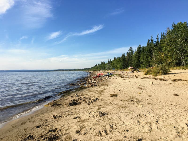 The beautiful sandy beaches along Marten Beach and the waters of slave lake in Northern Alberta, Canada on a warm summer day. The beach is endless. The beautiful sandy beaches along Marten Beach and the waters of slave lake in Northern Alberta, Canada on a warm summer day. The beach is endless.