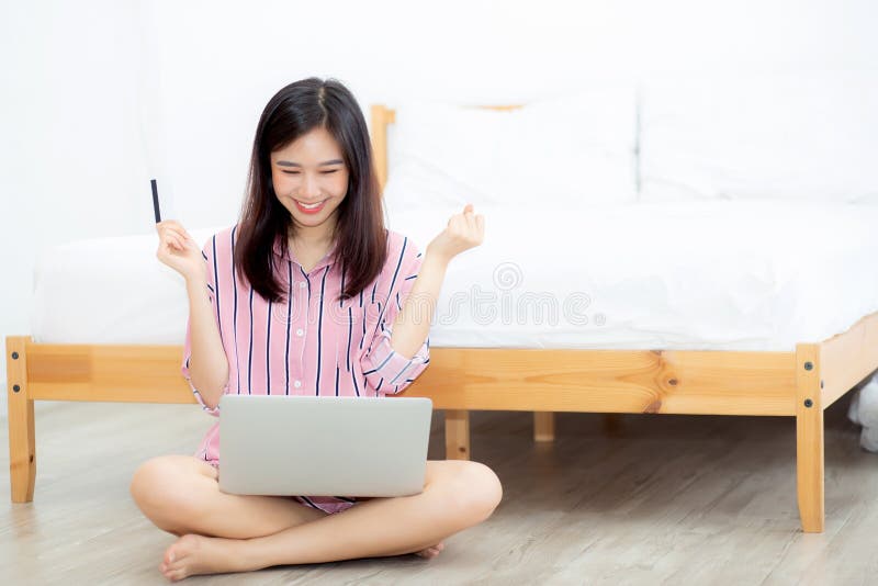 De mooie zitting die van de portret jonge Aziatische vrouw creditcard met laptop computer gebruikt royalty-vrije stock fotografie De mooie zitting die van de portret jonge Aziatische vrouw creditcard met laptop computer gebruikt royalty-vrije stock fotografie