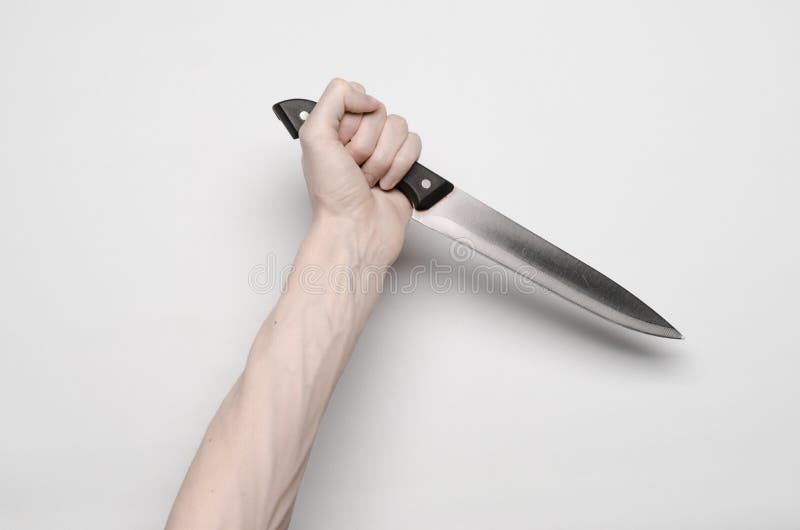 De moord en Halloween als thema hebben: Een man hand die voor een mes, een menselijke hand bereiken die een mes houden die op een stock fotografie De moord en Halloween als thema hebben: Een man hand die voor een mes, een menselijke hand bereiken die een mes houden die op een stock fotografie