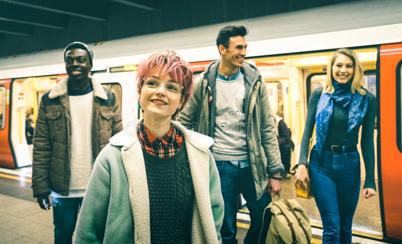 De multiraciale groep die van hipstervrienden bij de post van de buismetro lopen stock afbeeldingen De multiraciale groep die van hipstervrienden bij de post van de buismetro lopen stock afbeeldingen