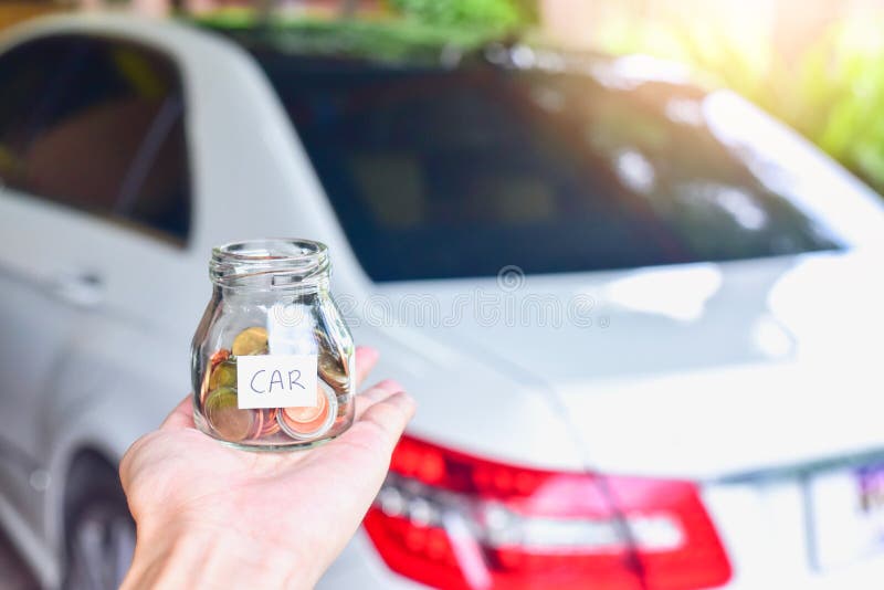 De Muntstukken van de handholding in Glaskruik met Autoetiket voor een Luxeauto royalty-vrije stock afbeeldingen De Muntstukken van de handholding in Glaskruik met Autoetiket voor een Luxeauto royalty-vrije stock afbeeldingen