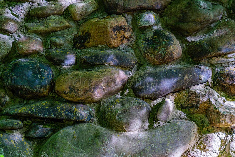 De muur van gekleurde keien maakte met cement, sporen vast van vorm, achtergrond stock afbeelding De muur van gekleurde keien maakte met cement, sporen vast van vorm, achtergrond stock afbeelding