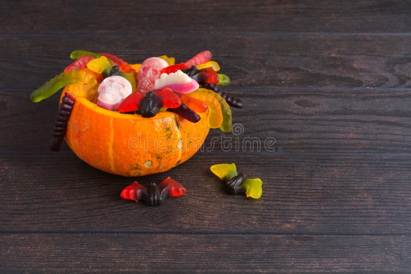 De natuurlijke pompoen van Halloween met divers suikergoed over houten achtergrond royalty-vrije stock foto's De natuurlijke pompoen van Halloween met divers suikergoed over houten achtergrond royalty-vrije stock foto's