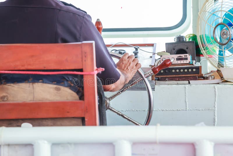 De navigatorroerganger is verantwoordelijk voor positie van veerboot door stuurwielroer, sternwheel in proefhuis te controleren stock foto's De navigatorroerganger is verantwoordelijk voor positie van veerboot door stuurwielroer, sternwheel in proefhuis te controleren stock foto's