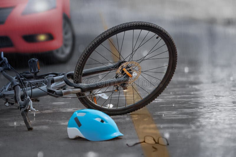 De neerstorting van de ongevallenauto met fiets op weg, regenachtige dag