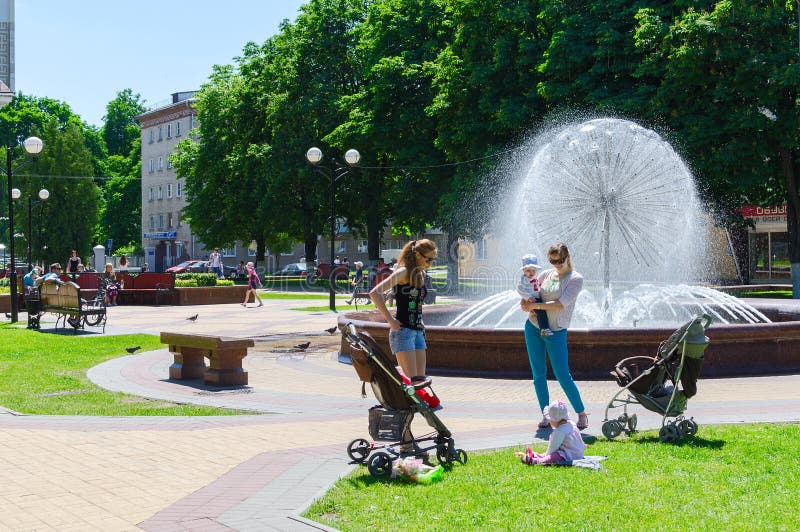 De niet geïdentificeerde mensen ontspannen bij fontein in park, Victory Sq stock foto De niet geïdentificeerde mensen ontspannen bij fontein in park, Victory Sq stock foto
