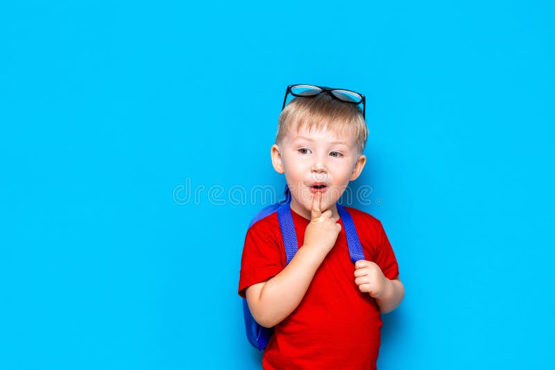De nouveau au portrait d'école de l'enfant étonné heureux en verres d'isolement sur le fond bleu avec l'espace de copie les nouve images libres de droits De nouveau au portrait d'école de l'enfant étonné heureux en verres d'isolement sur le fond bleu avec l'espace de copie les nouve images libres de droits