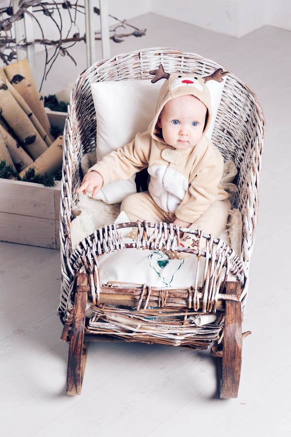 De ochtend van Kerstmis Meisje in de zitting van jumpsuitherten in toboggan stock foto's De ochtend van Kerstmis Meisje in de zitting van jumpsuitherten in toboggan stock foto's