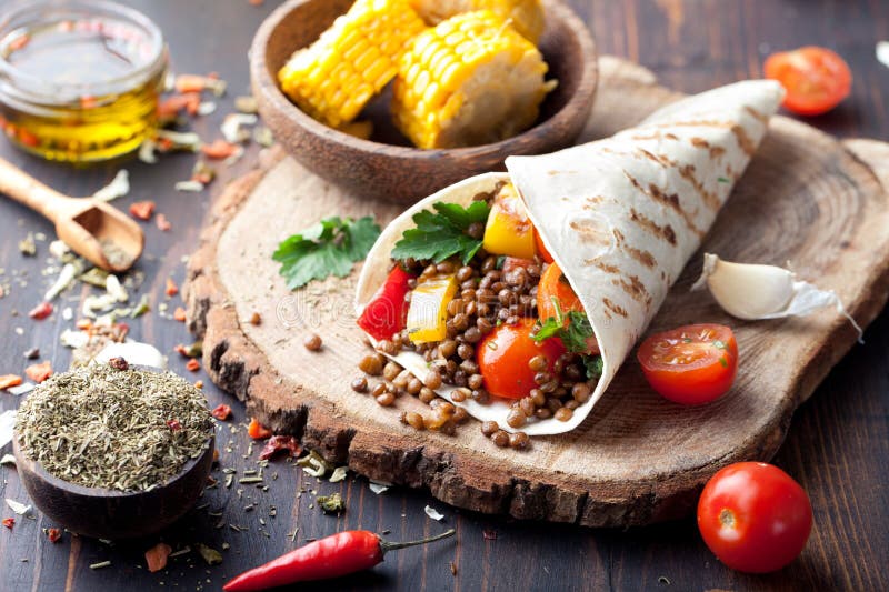 De omslag van de veganisttortilla, broodje met geroosterd vegetabes, linze, maïskolf royalty-vrije stock fotografie De omslag van de veganisttortilla, broodje met geroosterd vegetabes, linze, maïskolf royalty-vrije stock fotografie