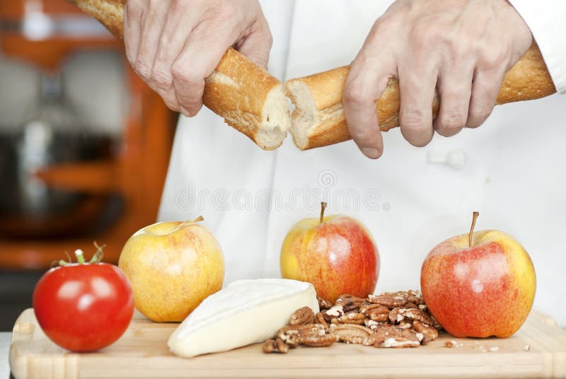 De Onderbrekingen Baguette van de chef-kok, sluiten royalty-vrije stock foto De Onderbrekingen Baguette van de chef-kok, sluiten royalty-vrije stock foto