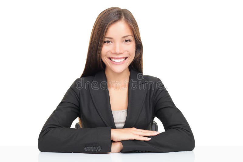 De onderneemsterzitting van Multiethnic bij bureau het glimlachen stock foto De onderneemsterzitting van Multiethnic bij bureau het glimlachen stock foto