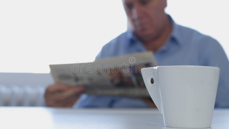 De ontspannen Zakenman Sitting op de Lijst las Krant en drinkt een Koffie royalty-vrije stock fotografie De ontspannen Zakenman Sitting op de Lijst las Krant en drinkt een Koffie royalty-vrije stock fotografie