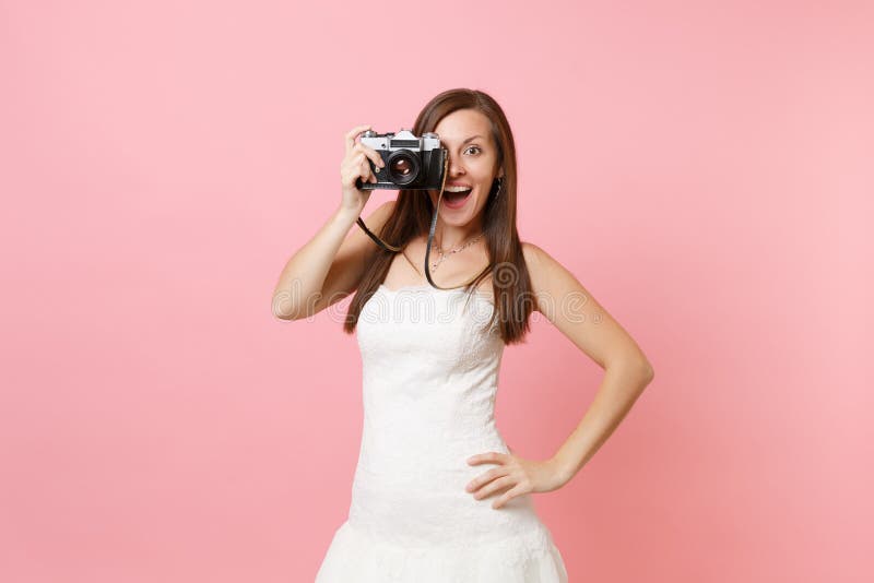 De opgewekte bruidvrouw in huwelijkskleding neemt beelden op retro uitstekende fotocamera, kiezend personeel, fotograaf stock fotografie De opgewekte bruidvrouw in huwelijkskleding neemt beelden op retro uitstekende fotocamera, kiezend personeel, fotograaf stock fotografie