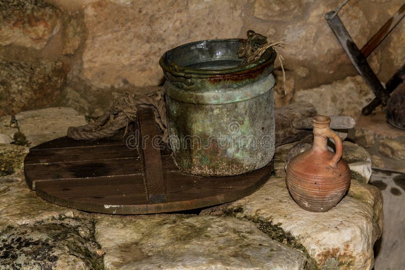 De Oude emmer en de kleikruik op de waterput in Nazareth Village, Israël